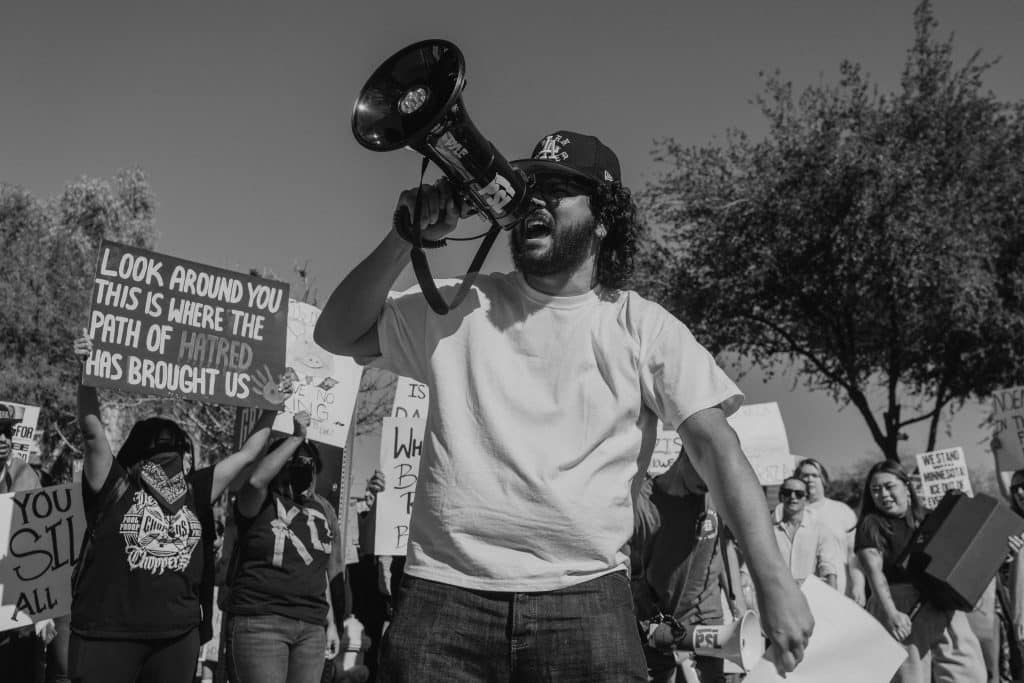 La protesta toma forma en la calle: consignas, carteles y una voz al frente que resume el sentir colectivo frente a las políticas migratorias.
